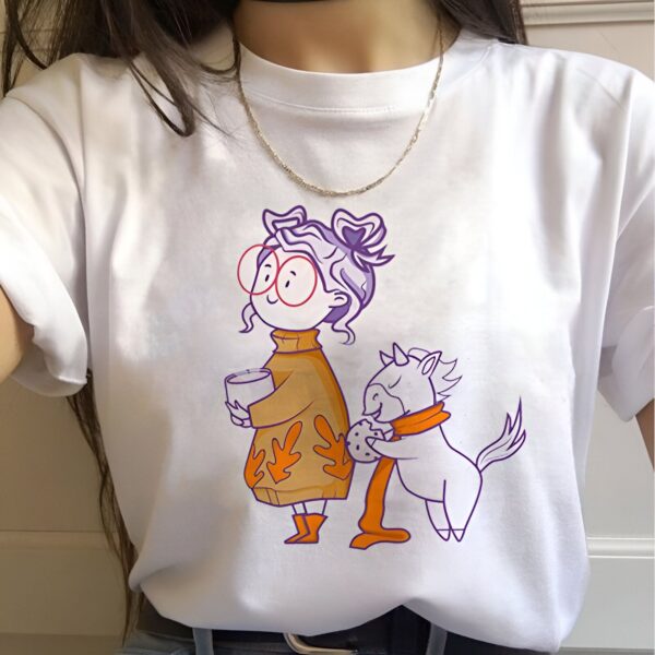 t-shirt-licorne-grand-mere-1a.jpg Une illustration d'une femme tenant une tasse de café et un biscuit à côté d'une licorne. La femme porte un pull orange et des bottes marron. La licorne a une écharpe violette.
