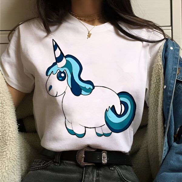 t-shirt-licorne-mouton-kawaii-1a.jpg Une jeune femme porte un t-shirt blanc avec un dessin d'une licorne dessus. La licorne est représentée avec une crinière et une queue bleues.