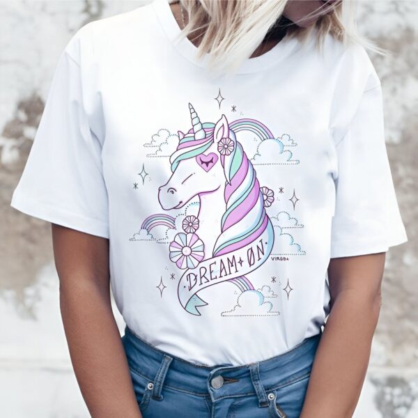 t-shirt-licorne-reveuse-1a.jpg Une illustration d'une licorne blanche avec une crinière et une queue arc-en-ciel. La licorne est entourée de nuages, d'étoiles et de fleurs. Le texte "Dream On" est écrit sur une banderole en dessous de la licorne.
