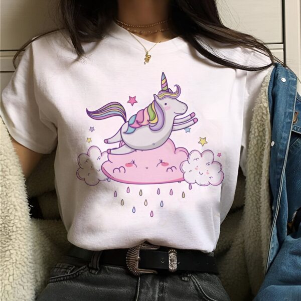 t-shirt-licorne-temps-pluvieux-1a.jpg Une illustration d'une licorne blanche avec une crinière et une queue arc-en-ciel sautant sur un nuage rose. La licorne est entourée d'étoiles et de nuages blancs.