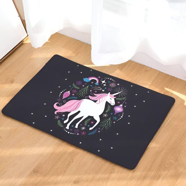 tapis-licorne-doux-antiderapant-pour-salle-de-bain-1a.jpg Tapis décoratif sur plancher en bois avec un motif de licorne blanche à crinière rose, entourée de décorations festives comme des étoiles, un arc-en-ciel et des ornements. Le fond du tapis est noir., 45501062480127 | Licorne Shop