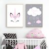 Une chambre de bébé avec deux tableaux. Le premier représente une licorne avec des fleurs dans les cheveux et le second un nuage avec des étoiles et l'inscription "Dream big little one".