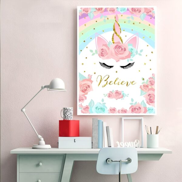 toile-licorne-fleurie-2a.jpg Une illustration d'une licorne blanche avec des fleurs roses et bleues dans sa crinière. Il y a un arc-en-ciel coloré au-dessus de la licorne et le mot "Believe" est écrit en lettres dorées sous la licorne.