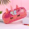 trousse-licorne-paillettes-rouge-1a.jpg Une trousse rose en forme de licorne avec des paillettes et des yeux.