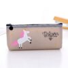 Une trousse transparente avec une licorne blanche et rose. Il y a des étoiles jaunes sur le devant de la trousse et le texte "Unicorn have a sweet dream" est écrit en lettres noires.