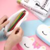 trousse-licorne-scolaire-3a.jpg Une trousse en peluche blanche en forme de licorne avec des étoiles et des yeux fermés. La trousse est ouverte et on peut voir des crayons de couleur à l'intérieur.