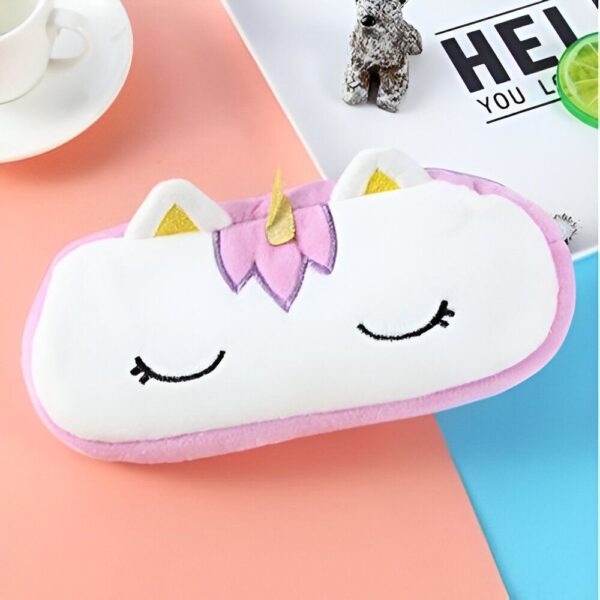trousse-licorne-scolaire-4a.jpg Une trousse en peluche blanche et rose en forme de licorne avec des oreilles et une corne dorées et des yeux et des ailes roses.