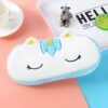 trousse-licorne-scolaire-8a.jpg Une trousse en peluche en forme de licorne blanche et bleue avec des étoiles et des yeux fermés.