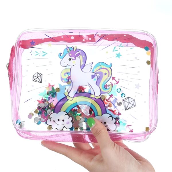 trousse-licorne-toilette-fille-1a.jpg Une trousse transparente avec un imprimé licorne. La licorne est blanche avec une crinière et une queue arc-en-ciel. Elle est debout sur un arc-en-ciel et il y a des étoiles et des nuages autour d'elle. La trousse est remplie de paillettes colorées.