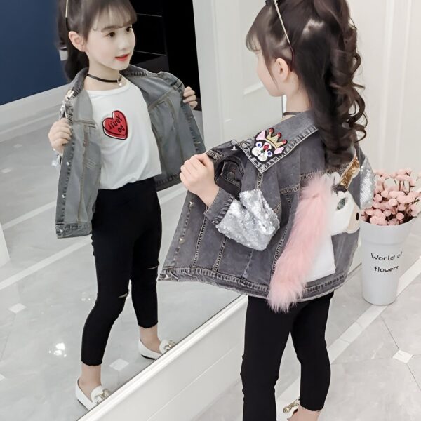 Fille avec une veste en jean décorée, se regardant dans un miroir. Elle porte un t-shirt blanc avec un cœur rouge, un pantalon noir et des chaussures blanches. Sa veste a un motif de chien couronné et une licorne avec une queue rose., 45501803921663,45501803954431,45501803987199,45501804019967,45501804052735,45501804085503,45501804118271,45501804151039 | Licorne Shop